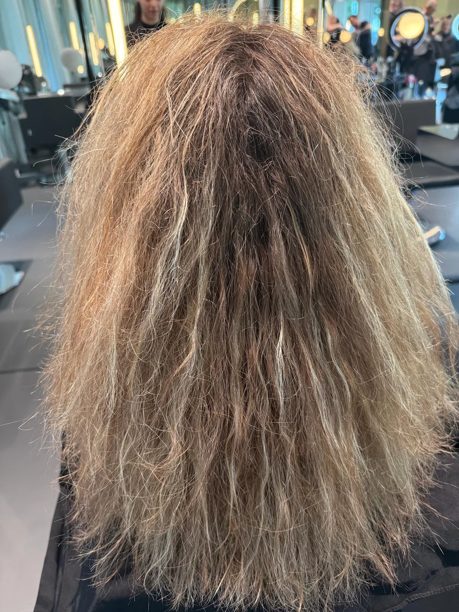 Langes blondes Haar vor der Keratinbehandlung: stark kraus, trocken, gebrochene Spitzen