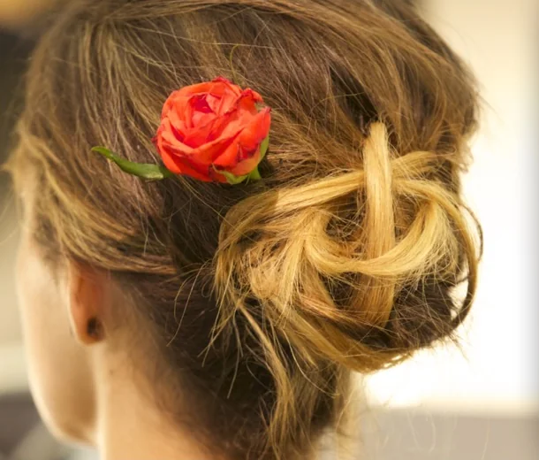 Hochsteckfrisur mit roter Rose an der Beauty-Party